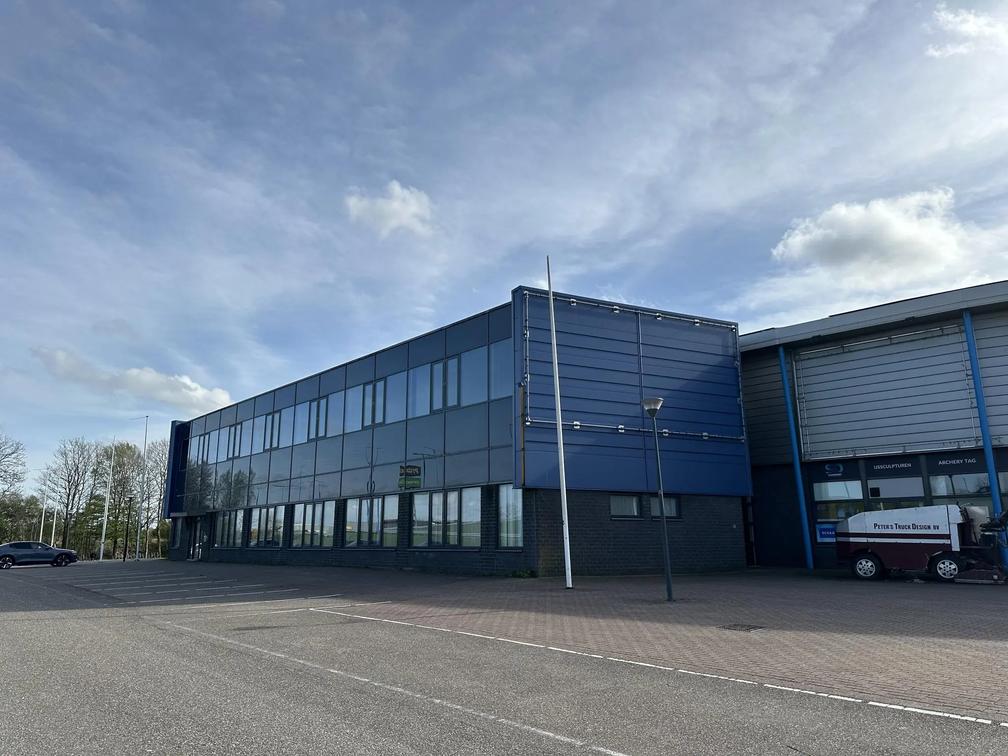 Bedrijfsgebouw aan de Van der Hagenstraat met een blauwe gevel en grote glazen ramen.